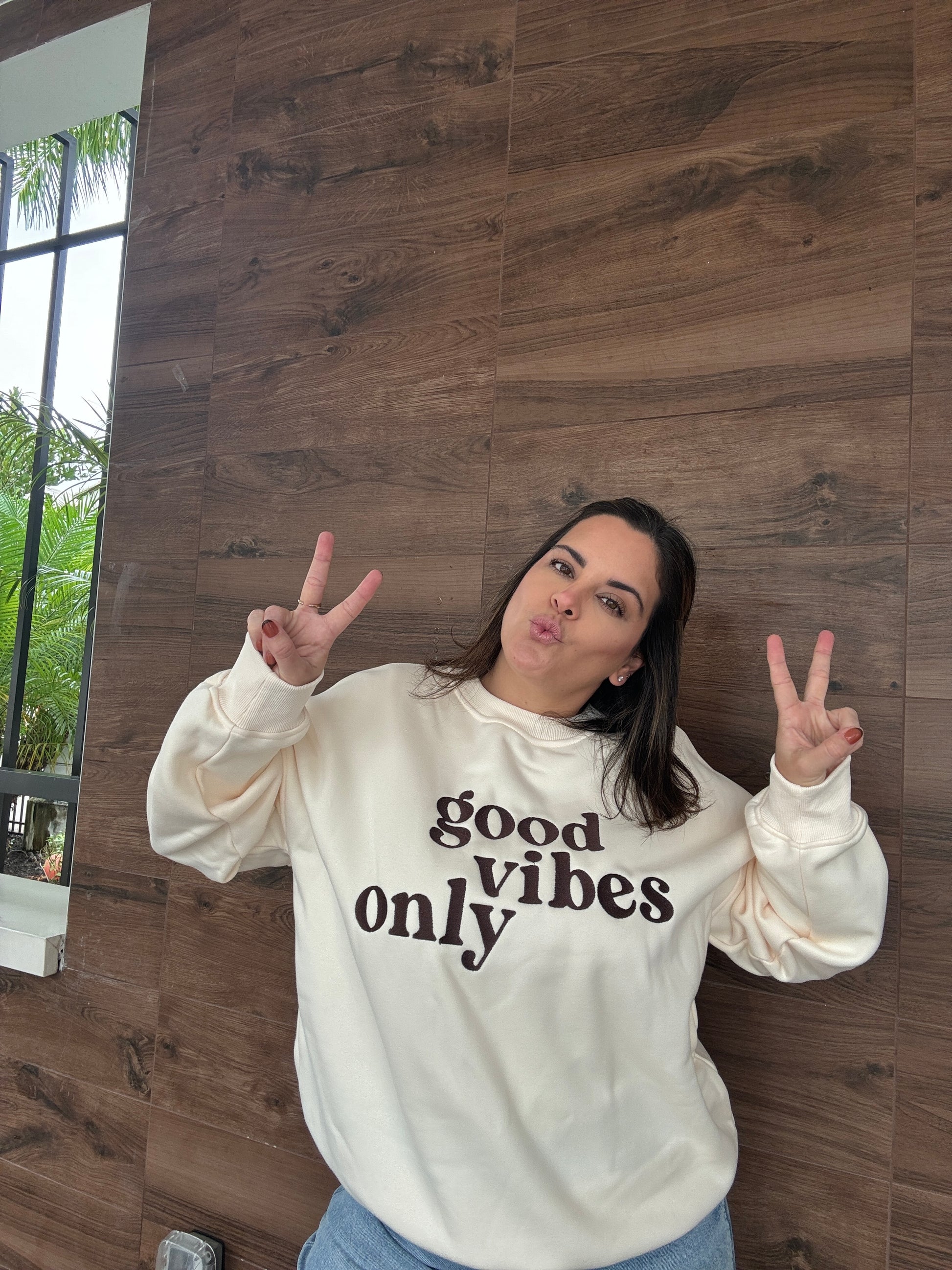 A ladies cream sweatshirt that says good vibes only.