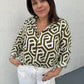 A women with a white and olive  Geometric printed long sleeve top 