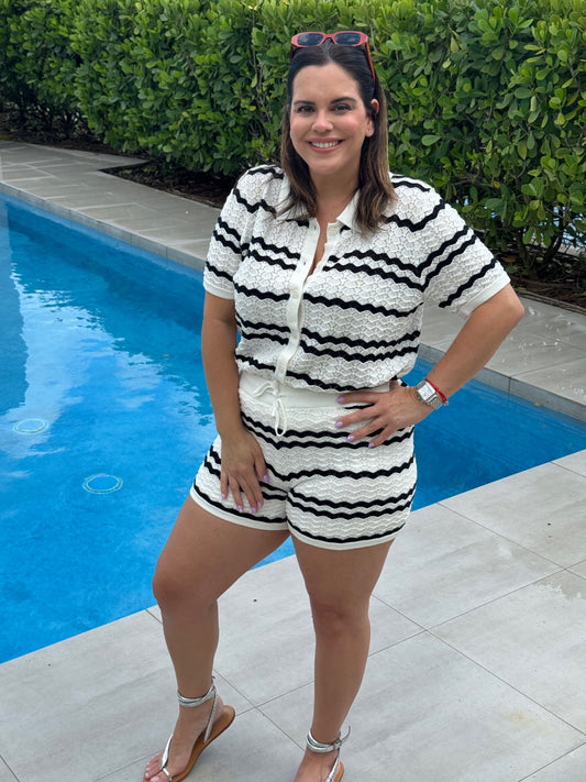 A woman poolside with red sunglasses wearing a black and white Chevron Stripe Knit Set