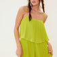 This photo shows a lime green romper with pleated detailing. The romper is made from 100% polyester and is perfect for a summer day or a night out.